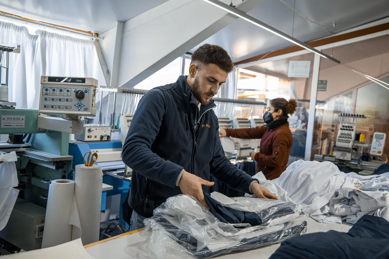 Prendas bordadas, dobladas y embaladas por tallas, listas para entregar