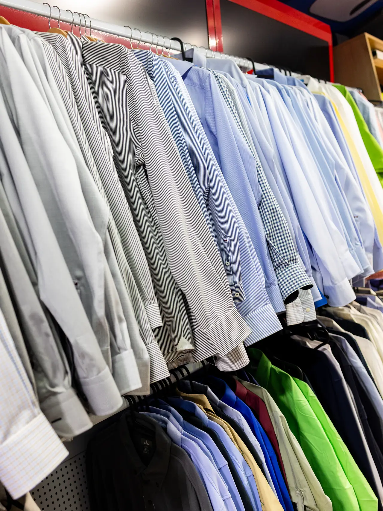 Camisas de uniforme colgadas por tallas en la tienda de uniformidad de Dyreco