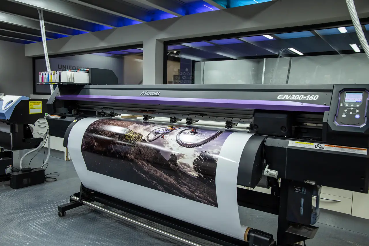 Plóter de gran formato imprimiendo un vinilo en la nave de rotulación de Dyreco