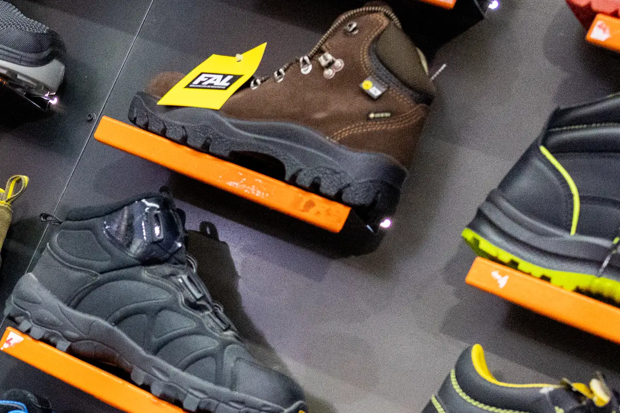 Bota de seguridad de piel marrón junto a una bota técnica negra en la tienda de Dyreco