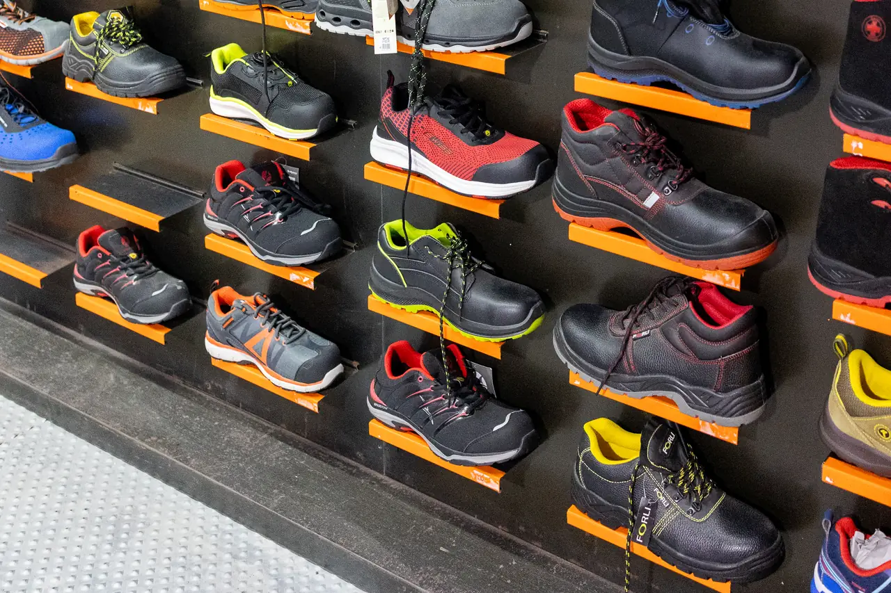 Zapatos y zapatillas de seguridad de varios modelos en la pared de calzado de Dyreco