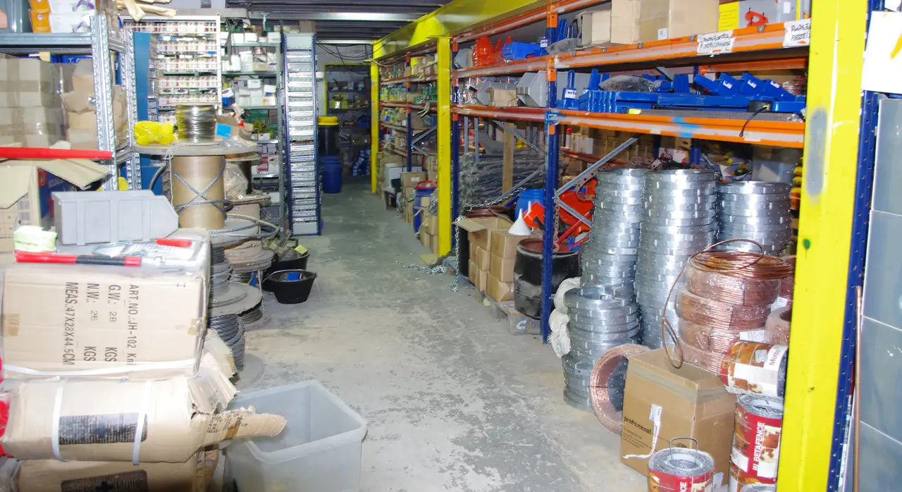 Pasillo del almacén de Dyreco con bobinas de cable eléctrico y rollos de tubo