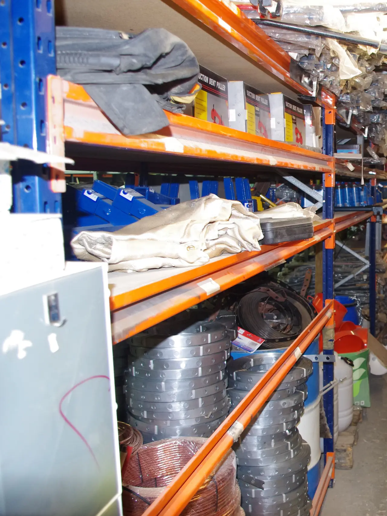 Rollos de tubo y material de instalación en las estanterías del almacén de Dyreco