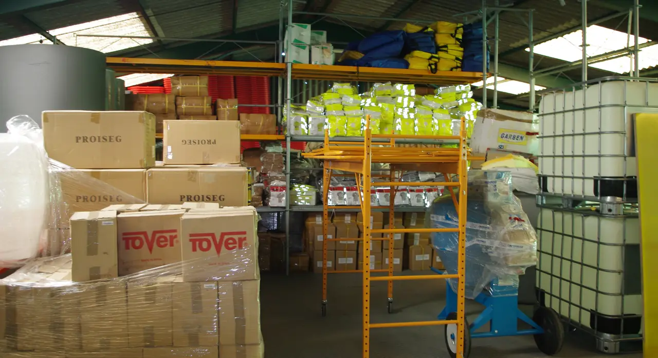 Cajas de EPIs, material de obra y escaleras en el almacén de Dyreco