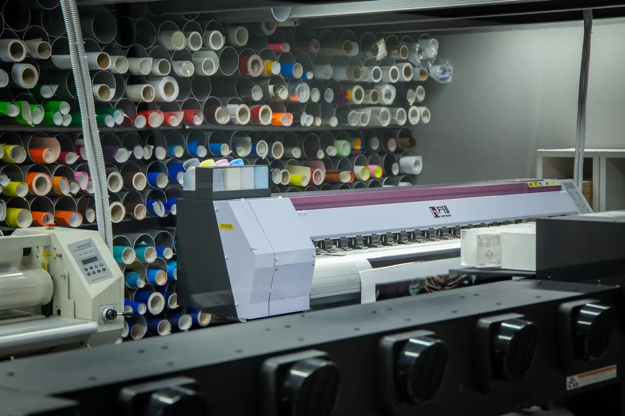 Impresora de gran formato y bobinas de vinilo en el taller de rotulación de Dyreco