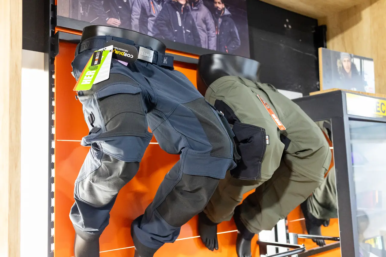 Pantalones de trabajo con rodilleras en el expositor de la tienda de uniformidad de Dyreco